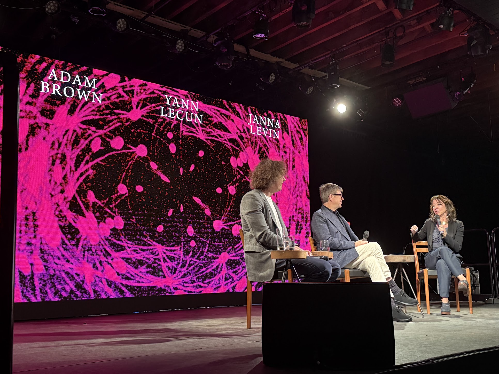 December 12, 2025 at Pioneerworks in Red Hook, Brooklyn. Theoretical physicist and Google DeepMind executive Adam Brown on stage next to AMI Labs CEO Yann LeCun and Columbia astrophysicist Janna Levin. Photo by Bret Kerr.