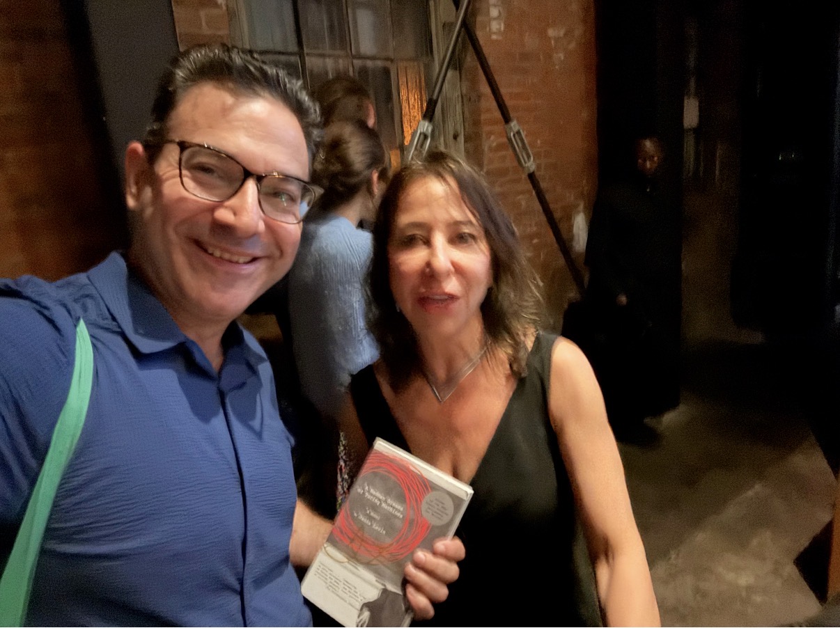 Bret Kerr with astrophysicist and author Janna Levin, holding up her novel A Madman Dreams of Turing Machines at a Pioneerworks event in conversation with American writer Gary Shteyngart, Red Hook, Brooklyn, 2025.